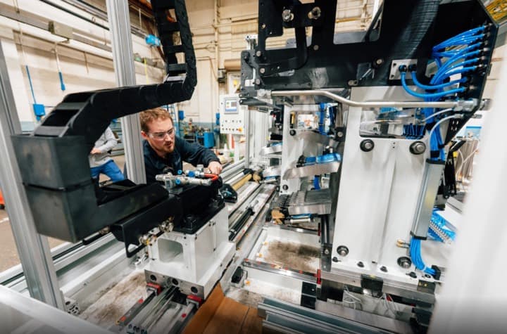 An engineer working on an automated assembly line on a factory floor